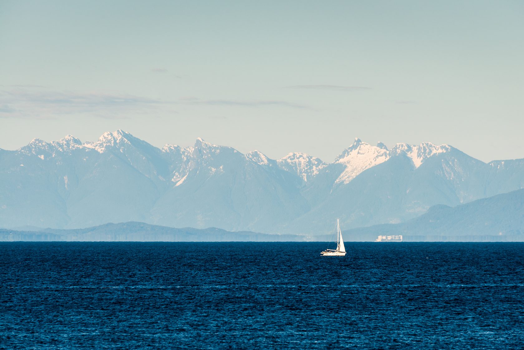 The Strait of Georgia from Neck Point in Nanaimo, with a sailboat and the snow-capped Coast Mountains across the water